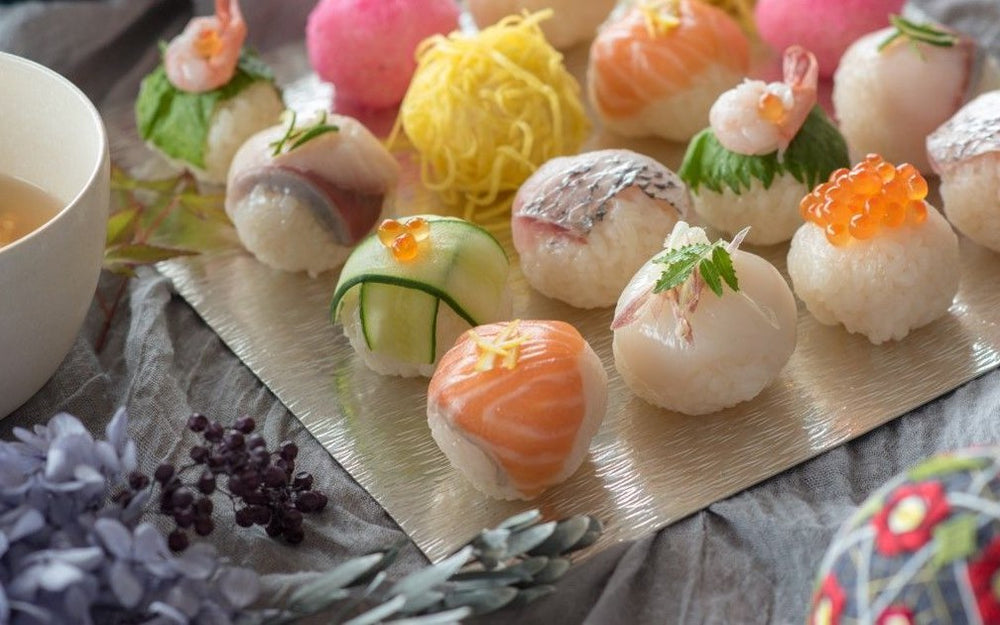 A platter of temari sushi balls topped with salmon, tuna and vegetables
